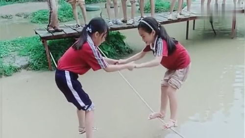 两个小姑娘在水里踩绳子,孩子真的太厉害了 