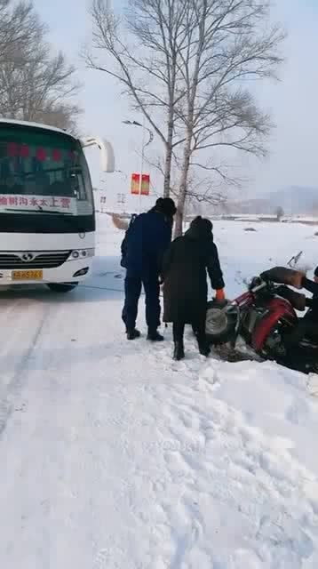 三轮车在地里滑到沟里,用大巴车帮忙拽出来,雪天路滑注意安全 